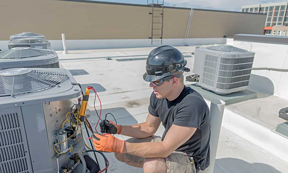 Technician servicing rooftop HVAC equipment