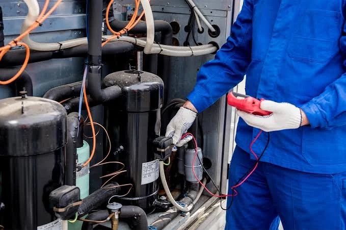 Technician testing compressor components during HVAC diagnostics