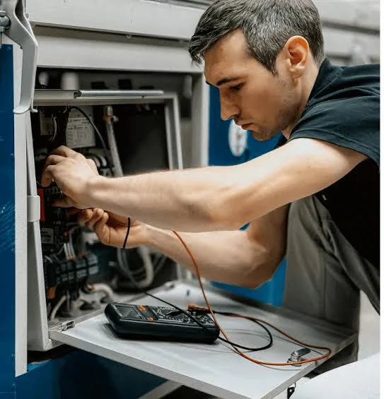 Technician using a meter while troubleshooting HVAC equipment